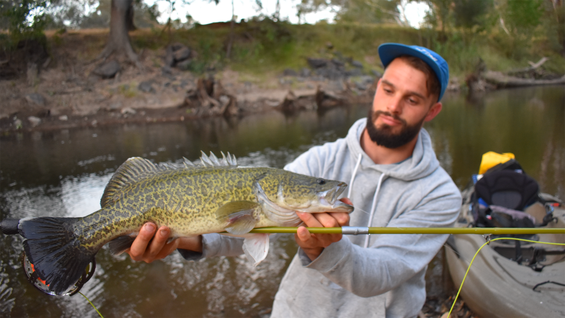 Local Angler standing next to river with Murray Cod in his hands
