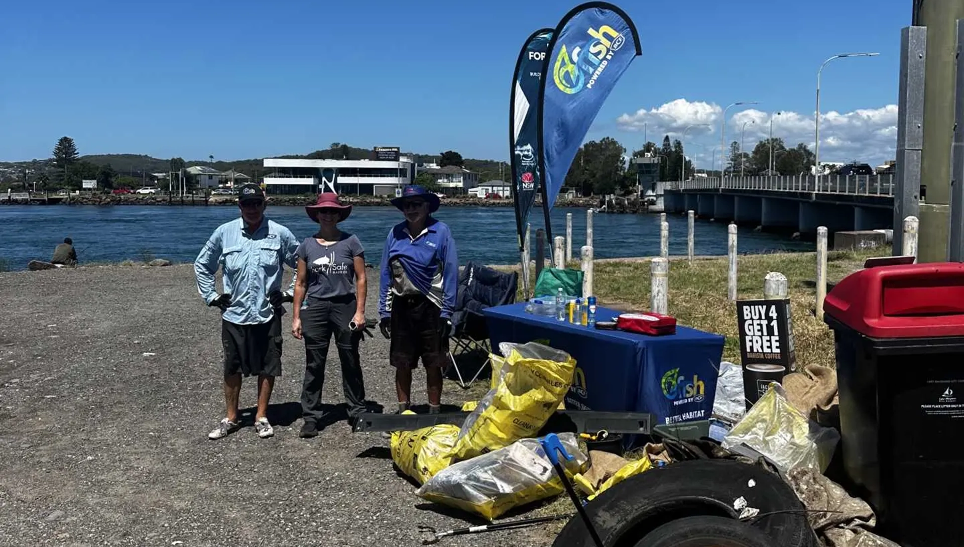 Volunteers standing by waterway with haul from clean up