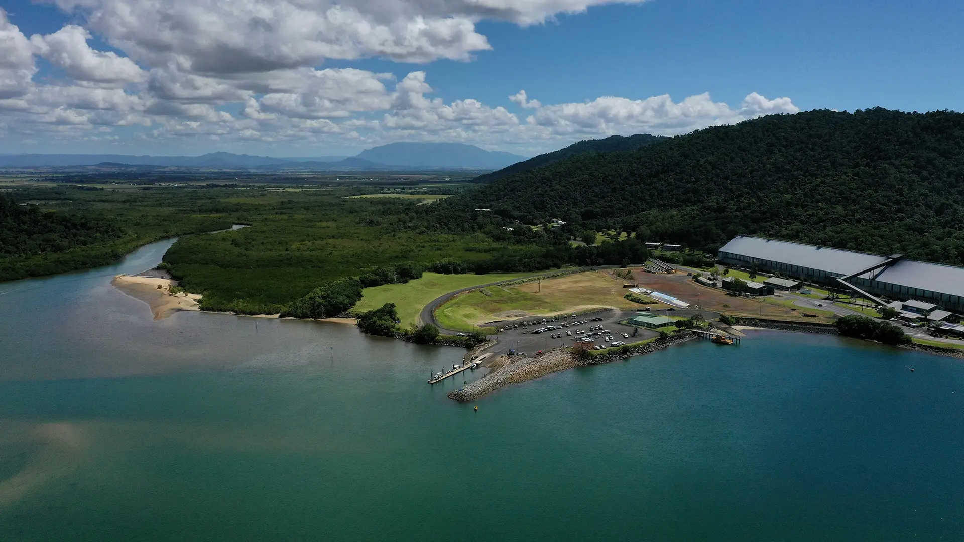 above shot of water meeting the land with a pier visible